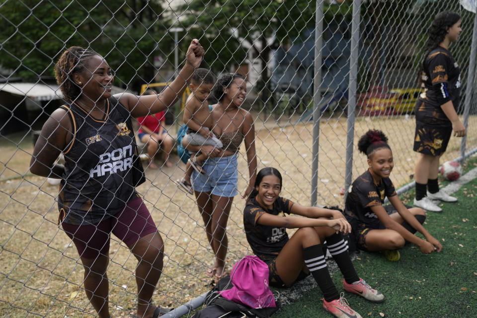 Familiares siguen un entrenamiento de jóvenes futbolistas como parte del programa social Bola de Ouro, en la favela Complexo da Alemao, en Río de Janeiro, Brasil, el 16 de mayo de 2024. Las adolescentes participan en programas de fútbol entrenados por activistas, donde reciben formación no solo deportiva sino para su desarrollo personal. (AP Foto/Silvia Izquierdo)