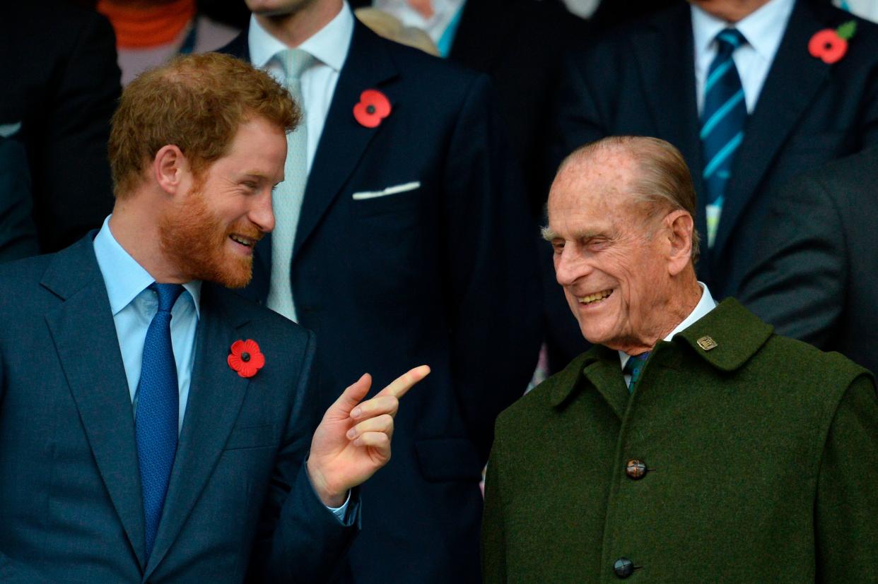 Prince Harry speaks with his grandfather Prince Philip as they watch the final match of the 2015 Rugby World Cup on Oct. 31, 2015. (Photo: GLYN KIRK via Getty Images)