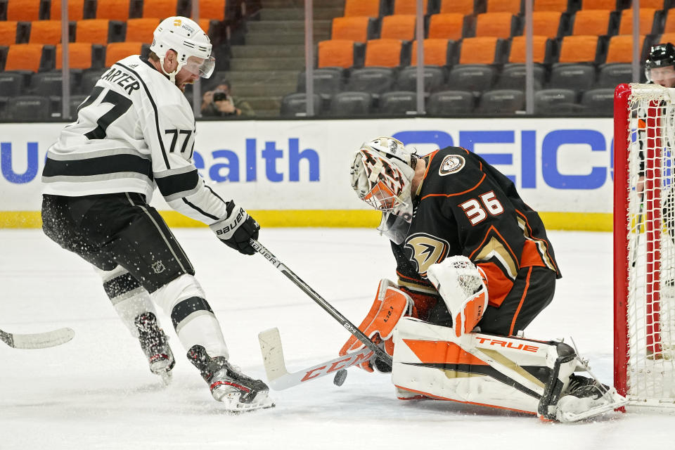 Anaheim Ducks goaltender John Gibson, right, stops a shot by Los Angeles Kings center Jeff Carter during the first period of an NHL hockey game Monday, March 8, 2021, in Anaheim, Calif. (AP Photo/Mark J. Terrill)