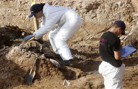 Forensic experts, members of the International Commision of Missing Persons (ICMP) and Bosnian workers search for human remains at a mass grave in the village of Tomasica near Prijedor, October 22, 2013. REUTERS/Dado Ruvic