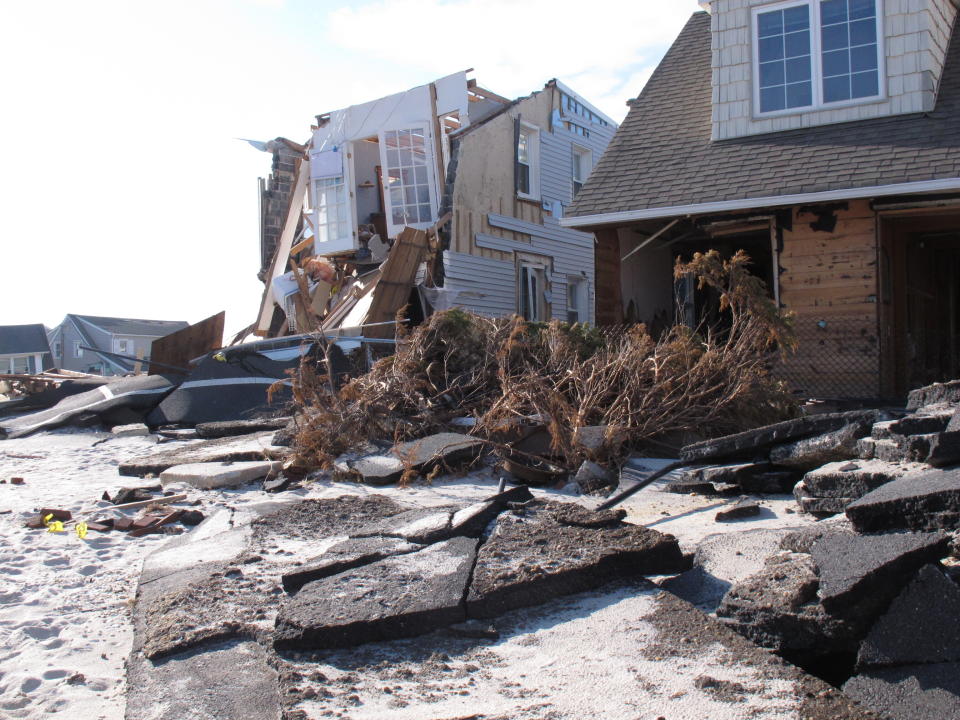 This Nov. 29, 2012 photo shows homes along the oceanfront in Toms River N.J. next to smashed pavement that was destroyed in Superstorm Sandy. On the 10th anniversary of the storm, government officials and residents say much has been done to protect against the next storm, but caution that much more still needs to be done to protect against future storms. (AP Photo/Wayne Parry)