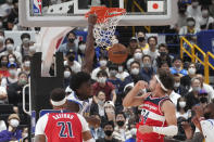 Golden State Warriors' James Wiseman, center, dunks against Washington Wizards' Daniel Gafford, left, and Washington Wizards' Corey Kispert, right, during their preseason NBA basketball game, Friday, Sept. 30, 2022, at Saitama Super Arena, in Saitama, north of Tokyo. (AP Photo/Eugene Hoshiko)