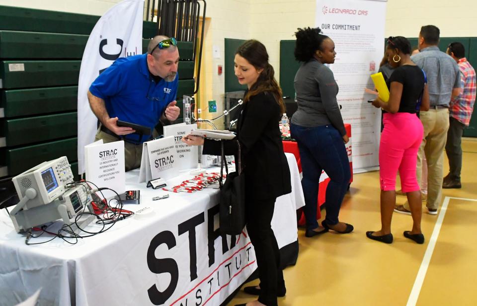 Clyde Dolly of STRAC Institute talks with Christina Nichols of Titusville at the CareerSource Brevard Job Fair.