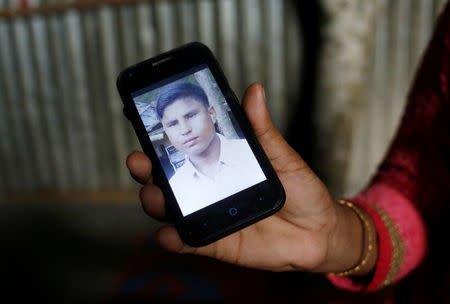 Noor Ankis shows the picture of her husband Ayub, a leader of the unregistered makeshift camp in Kutupalong, who was killed late last month, in Cox’s Bazar, Bangladesh, July 9, 2017. REUTERS/Mohammad Ponir Hossain