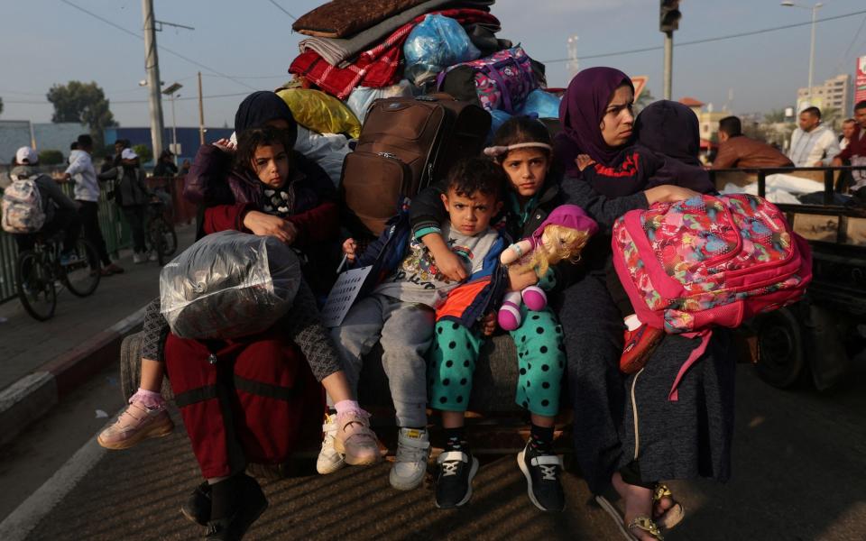 Palestinian women with children flee their houses after Israeli strikes resumed on Friday