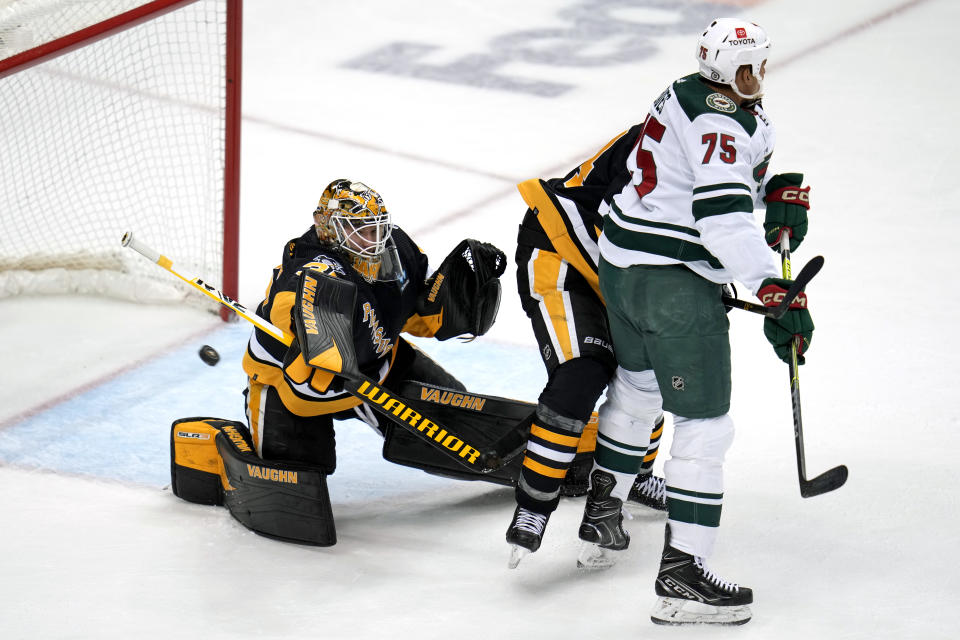 Pittsburgh Penguins goaltender Tristan Jarry (35) deflects a shot during the third period of an NHL hockey game against the Minnesota Wild in Pittsburgh, Thursday, April 6, 2023. (AP Photo/Gene J. Puskar)