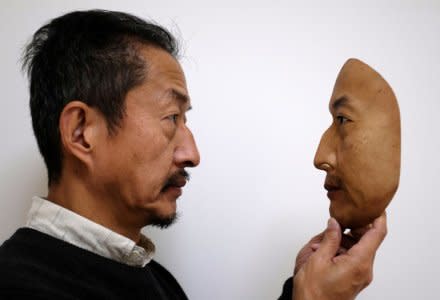 REAL-f Co. President Osamu Kitagawa holds a super-realistic face mask at his factory in Otsu, western Japan, November 15, 2018.  REUTERS/Kwiyeon Ha