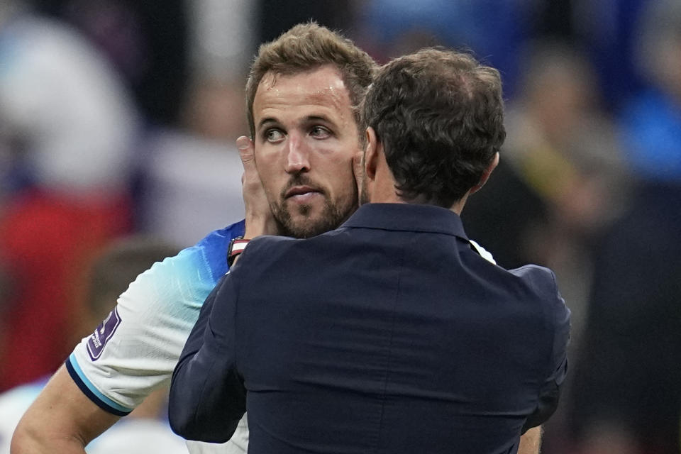 England's Harry Kane is comforted by head coach Gareth Southgate after losing 1-2 against France during the World Cup quarterfinal soccer match between England and France, at the Al Bayt Stadium in Al Khor, Qatar, Sunday, Dec. 11, 2022. (AP Photo/Abbie Parr)