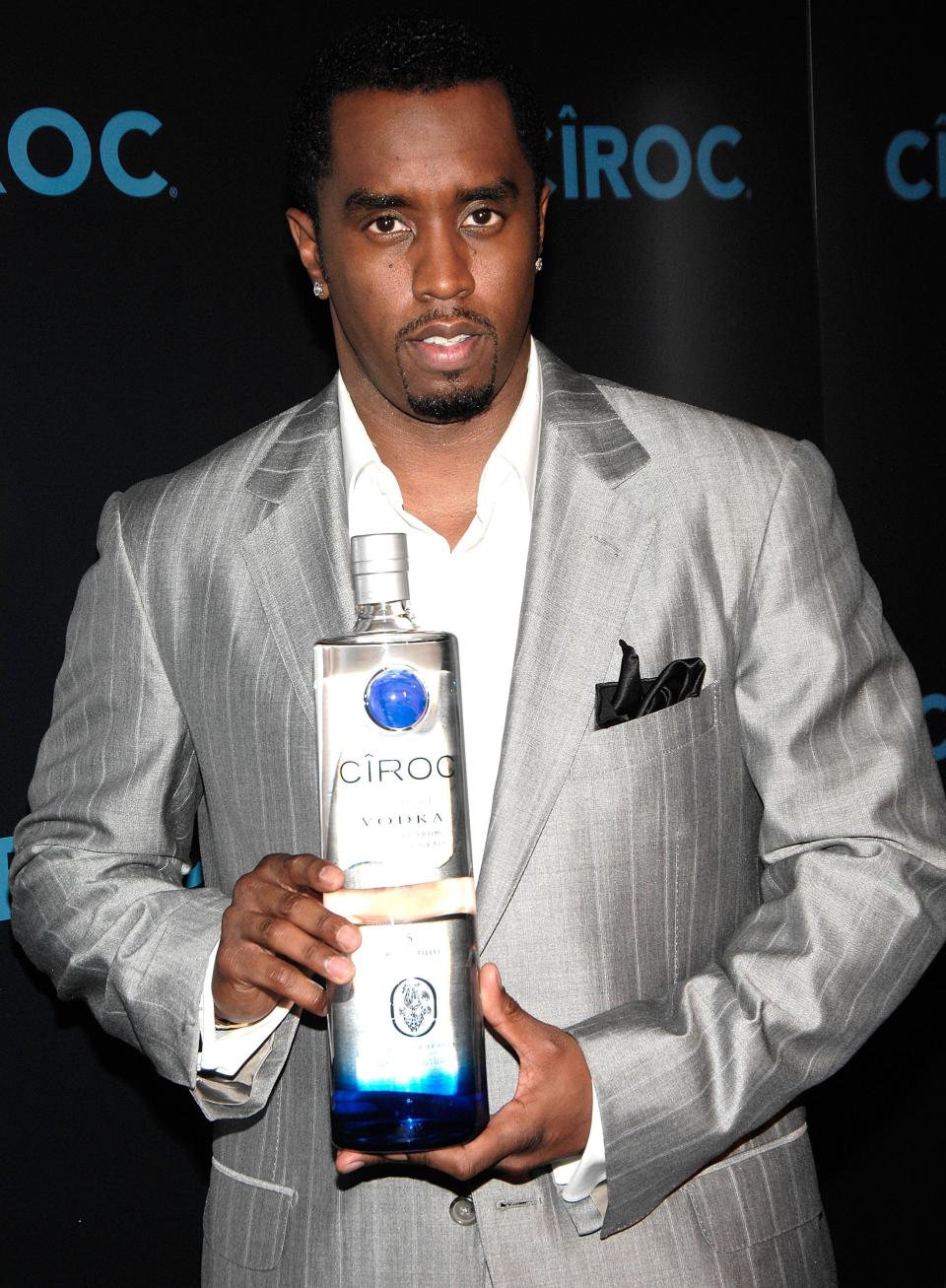 Sean Combs in a silver suit holding a bottle of Ciroc