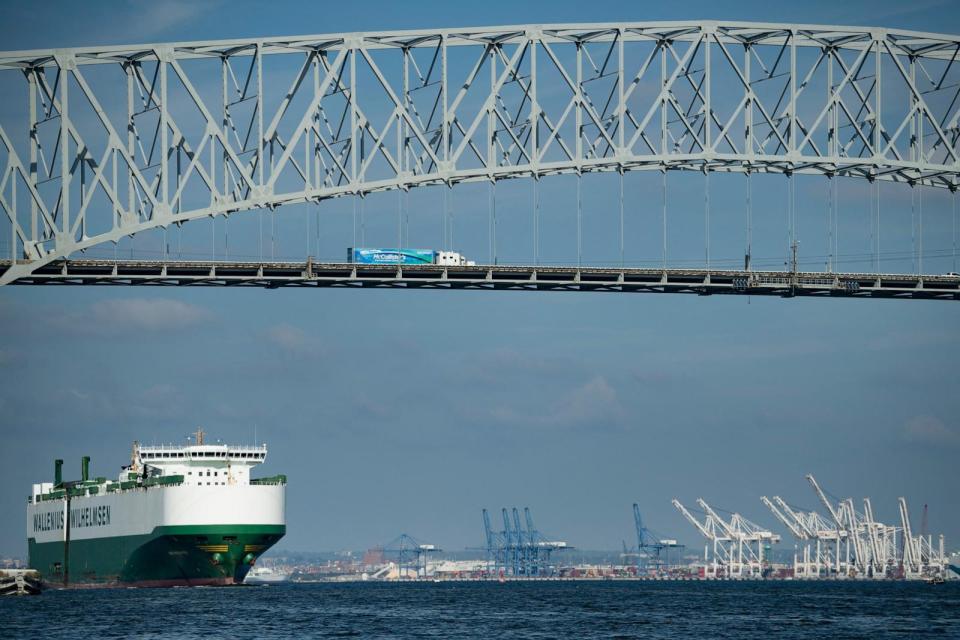 PHOTO: A cargo ship passes below the Francis Scott Key Bridge while leaving the Port of Baltimore, Oct. 14, 2021, in Baltimore. (Brendan Smialowski/AFP via Getty Images)