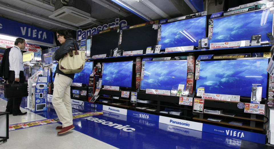 People inspect flat-panel TVs at a discount store in Tokyo Friday, Oct. 26, 2012. Japan's Cabinet approved a 423 billion yen ($5.3 billion) economic stimulus package on Friday, moving to fend off recession amid signs the recovery in the world's third biggest economy is faltering. The decision coincided with news of a 0.1 percent fall in the consumer price index in September, adding to pressure on the central bank to ease policies to help fight deflation, or falling prices, which can hinder economic growth. (AP Photo/Koji Sasahara)