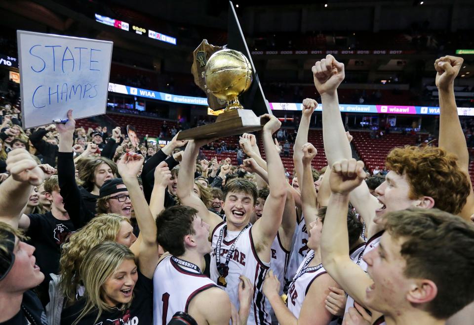 De Pere's Gabe Herman (2) holds up the WIAA Division 1 state basketball championship trophy after the Redbirds' 69-49 victory over Arrowhead in the title game March 18 at the Kohl Center in Madison. The Redbirds completed an undefeated season in earning the championship win.