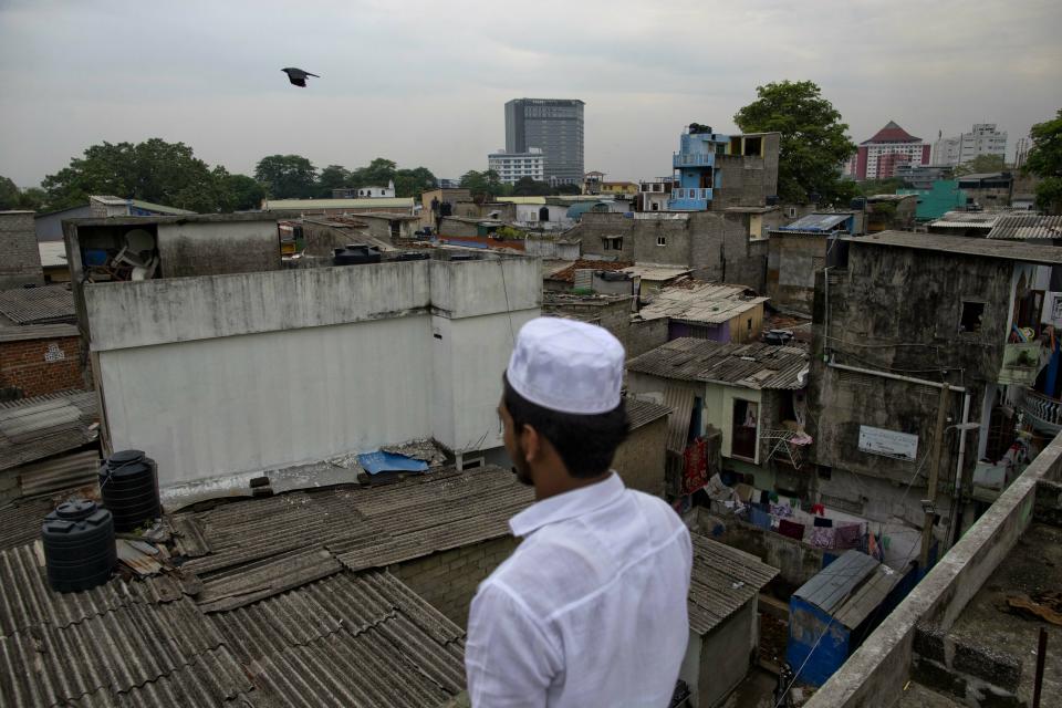 A Muslim volunteer stands in a roof of a mosque to spot possible attackers during Friday prayers in Colombo, Sri Lanka, Friday, April 26, 2019. Religious leaders cancelled large public gatherings amid warnings of more attacks, along with retaliatory sectarian violence in Sri Lanka though some still held communal Friday prayers at mosques. (AP Photo/Gemunu Amarasinghe)