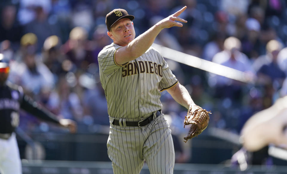 San Diego Padres relief pitcher Mark Melancon throws to first base to put out Colorado Rockies' Raimel Tapia for the final out in the sixth inning of game one of a baseball doubleheader Wednesday, May 12, 2021, in Denver. (AP Photo/David Zalubowski)