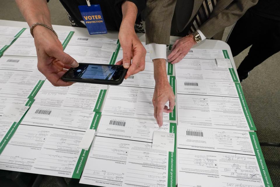 FILE - A canvas observer photographs Lehigh County provisional ballots as vote counting in the general election continues, Nov. 6, 2020, in Allentown, Pa. A review by The Associated Press in the six battleground states disputed by former President Trump has found fewer than 475 cases of potential voter fraud, a minuscule number that would have made no difference in the 2020 presidential election. Democrat Joe Biden won Arizona, Georgia, Michigan, Nevada, Pennsylvania and Wisconsin and their 79 Electoral College votes by a combined 311,257 votes out of 25.5 million ballots cast for president. (AP Photo/Mary Altaffer, file)