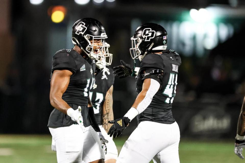 Cal Poly Mustangs defensive lineman Elijah Ponder (14) celebrates a first-half sack with Cal Poly Mustangs defensive lineman Julius Jordan (49). Cal Poly hosted Weber State at Mustang Memorial Field.