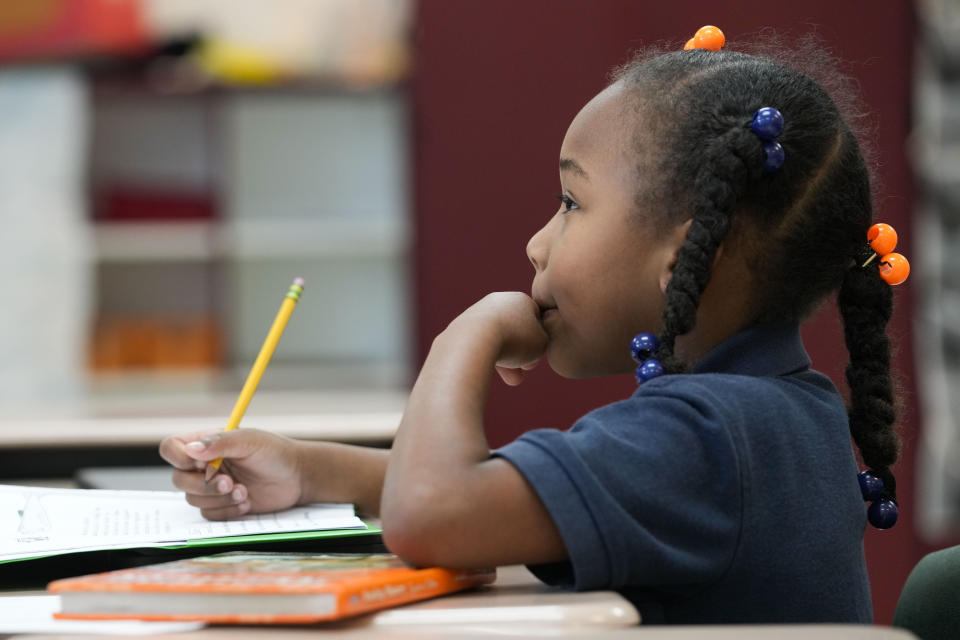 Second grader Demi Hill, 8, listens during class at Schaumburg Elementary, part of the ReNEW charter network, in New Orleans, Wednesday, April 19, 2023. (AP Photo/Gerald Herbert)