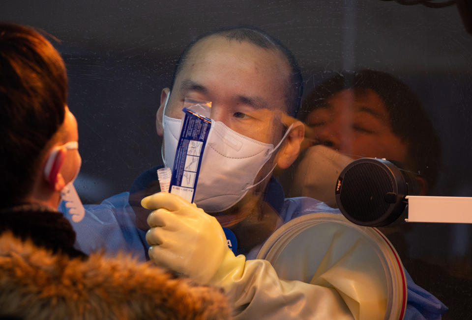 A health worker collects swabs from a citizen for COVID-19 testing at a makeshift clinic outside the Seoul city hall on Jan. 5<span class="copyright">Jeon Heon-Kyun—EPA-EFE/Shutterstock</span>