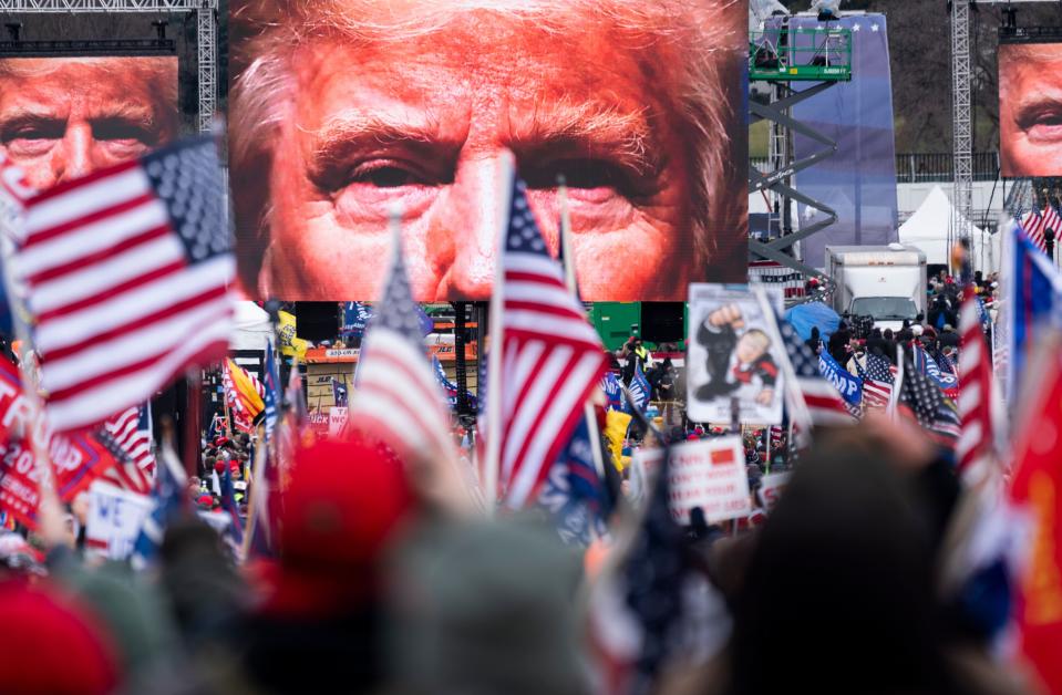 An image of President Donald Trump appears on video screens before his speech to his supporters on Jan. 6, 2021. (Bill Clark/CQ-Roll Call, Inc via Getty Images))