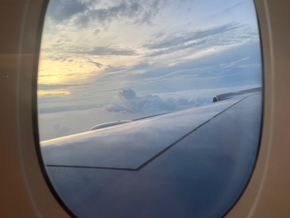 A view out the window with clouds and the wing.