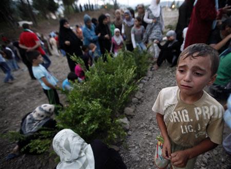 A Syrian refugee boy cries as he attends the funeral of five Free Syrian Army fighters, killed by Syrian security forces near the Idlib province of Syria, in Yayladagi in Hatay province near the Turkish-Syrian border, in this August 4, 2012 file photo. REUTERS/Umit Bektas/Files