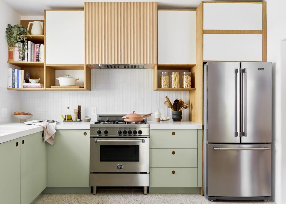 Clean design kitchen with light green lower cabinets and tambour exhaust hood