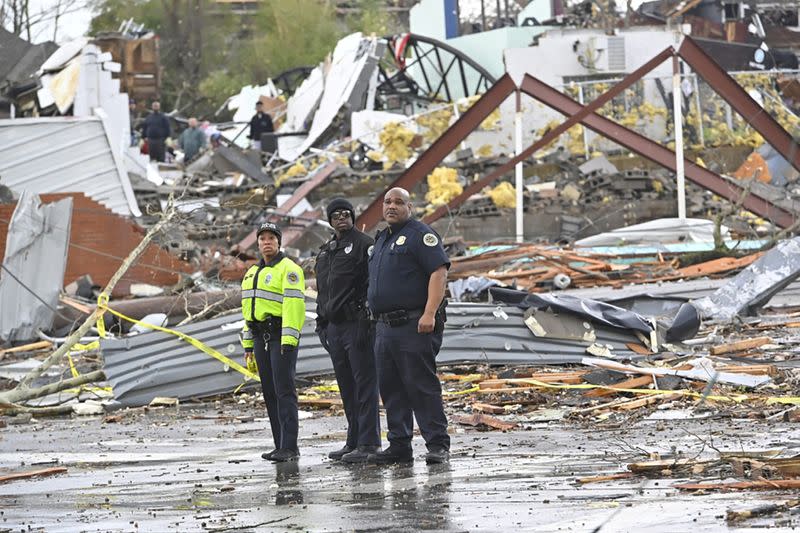 Police officers view damage along Woodland Street after a tornado touched down in Nashville
