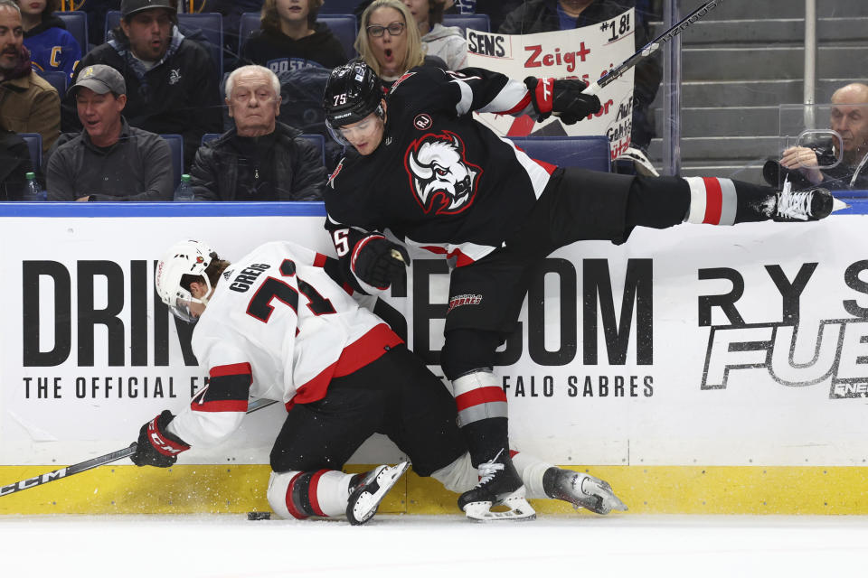Ottawa Senators center Ridly Greig (71) is checked by Buffalo Sabres defenseman Connor Clifton (75) during the second period of an NHL hockey game Thursday, Jan. 11, 2024, in Buffalo, N.Y. (AP Photo/Jeffrey T. Barnes)