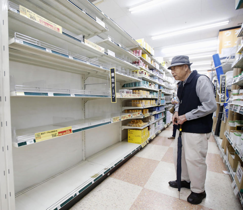 A man who wanted to buy curing tape, stands in front of empty shelves at a home improvement center in Yokohama, near Tokyo Friday, Oct. 11, 2019. A typhoon was forecast to bring 2 feet of rain and damaging winds to the Tokyo area and central Japan's Pacific coast this weekend, and the government warned people Friday to stockpile and leave high-risk places before it's too dangerous. (Shohei Miyano/Kyodo News via AP)