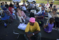 Neighbors gather outside a shelter afraid of aftershocks after an earthquake in Guanica, Puerto Rico, Tuesday, Jan. 7, 2020. A 6.4-magnitude earthquake struck Puerto Rico before dawn on Tuesday, killing one man, injuring others and collapsing buildings in the southern part of the island. (AP Photo/Carlos Giusti)