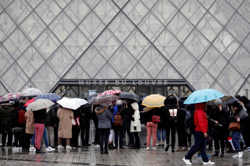 Los turistas hacen cola para entrar en el Louvre cuando el personal cerró el museo durante una reunión de personal sobre el brote de coronavirus, en París, Francia