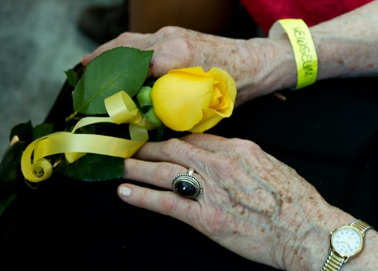 Colvin's mother Rosemarie Colvin holds a rose in memory of her daughter at a memorial