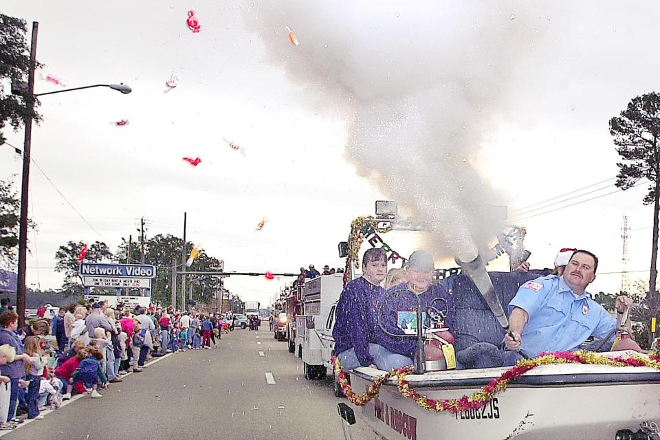 Jim Fields of the Niceville Fire Department shoots candy to spectators during the Twin Cities Christmas Parade in Niceville on Dec. 3, 2000. DAILY NEWS FILE PHOTO