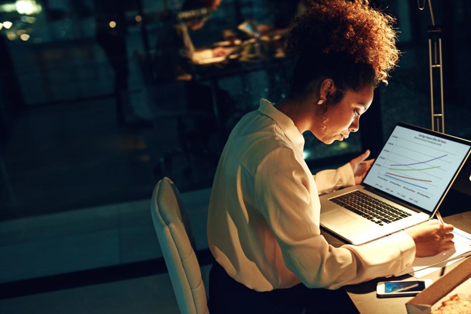 An investor looks at a computer screen in a darkened office.