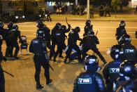 Police use truncheons on protesters during a mass protest following presidential election in Minsk, Belarus, Monday, Aug. 10, 2020. Thousands of people have protested in Belarus for a second straight night after official results from weekend elections gave an overwhelming victory to authoritarian President Alexander Lukashenko, extending his 26-year rule. A heavy police contingent blocked central squares and avenues, moving quickly to disperse protesters and detained dozens. (AP Photo/Sergei Grits)