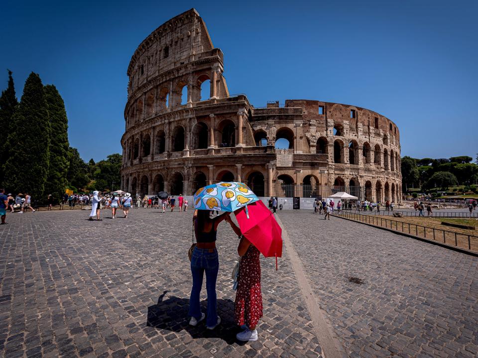 Tourists with umbrellas to protect themselves from the sun at Colosseum during a heat wave on July 18, 2023 in Rome, Italy.