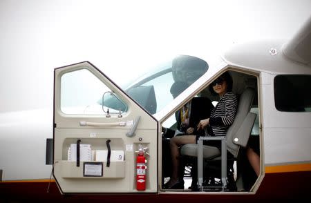 A guest sits in the pilot seat during a tour of a Cessna Grand Caravan aircraft during the Shanghai International Business Aviation Show at the Hongqiao International Airport in Shanghai in this April 16, 2013 file photograph. REUTERS/Carlos Barria/Files