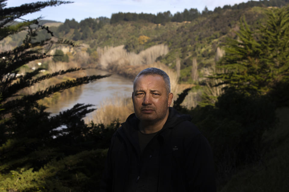 Gerrard Albert, the lead Maori negotiator in the Whanganui River treaty settlement, which saw the river given personhood status, stands for a portrait overlooking his ancestral settlement on the river near the town of Whanganui, New Zealand, on June 15, 2022. Before, Albert says, the tribe constantly had to make the case for protecting the river to an ever-changing cast of local councilors and politicians in the capital, Wellington. The people who made the rules, he says, were the planners, the lawyers and the businesspeople. (AP Photo/Brett Phibbs)