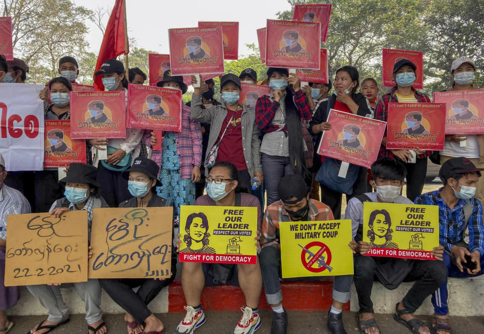 Anti-coup protesters display pictures of deposed Myanmar leader Aung San Suu Kyi and aprotester who was shot and killed by Myanmar security forces during a protest two-days earlier as they gather to protest in Yangon, Myanmar Tuesday, Feb. 23, 2021. Protesters gathered in Myanmar's biggest city despite the ruling junta's threat to use lethal force against people who join a general strike against the military's takeover three weeks ago. (AP Photo)