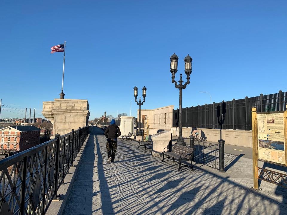 Pedestrians walk on a large path to the left and bikes ride to the right on the Washington Street bridge on Dec. 14, 2023.