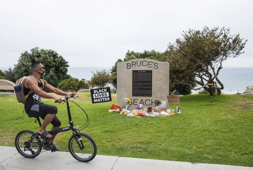 MANHATTAN BEACH, CA - JULY 29, 2020: A memorial to Emmett Till is located in front of a commemorative plaque at Bruce's Beach, a park located in Manhattan Beach. Till was a 14-year-old African American who was lynched in Mississippi in 1955. Bruce's Beach used to be owned by one of the first prominent Black oceanfront homeowners (in the 1920's) but Manhattan Beach ran them out of town and erased/rewrote the history of what happened. A new generation of residents are now calling on the city to confront its racist past. Many have reclaimed the space in recent weeks to celebrate and honor the Black Lives Matter movement. (Mel Melcon / Los Angeles Times)