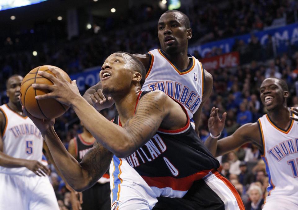 Portland Trail Blazers guard Damian Lillard (0) looks for a shot in front of Oklahoma City Thunder forward Serge Ibaka (9) in the second quarter of an NBA basketball game in Oklahoma City, Tuesday, Jan. 21, 2014. (AP Photo/Sue Ogrocki)