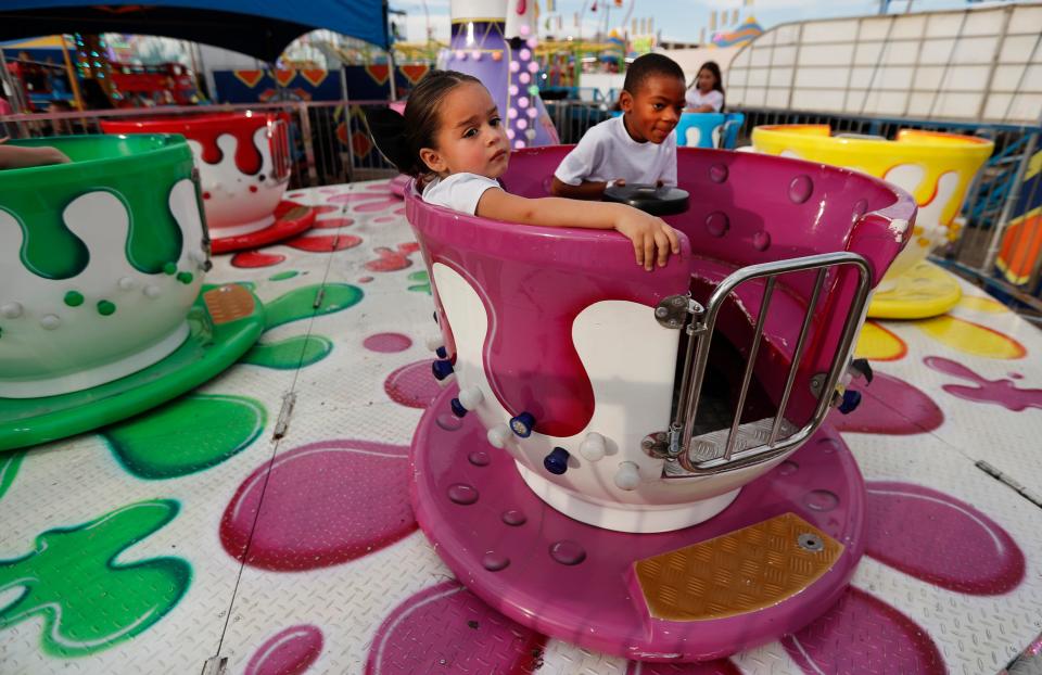 From left, 3-year-old Rae Martell and her 5-year-old brother Ty Martell, of Lubbock, ride in the Mini Tea Cup ride during preview night at the Panhandle South Plains Fair Thursday, September 21, 2023.