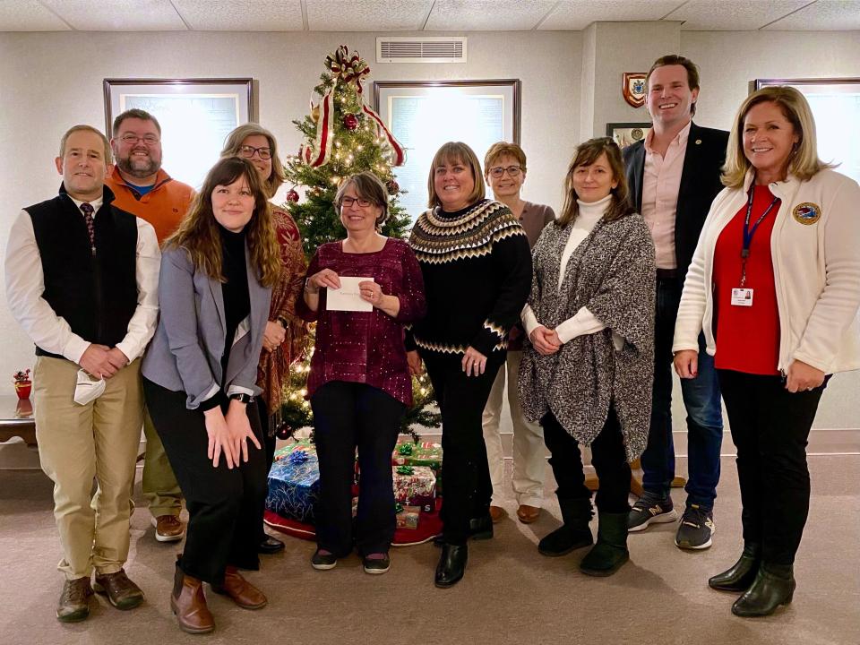 PMA members Laura Horwood-Benton, Cindy Chase, Kristin Shaw, Terry Poulin, and Rosann Maurice-Lentz present donations to Lisa Zhe of Families First and Seneca Adam Bernard of Gather NH. Also pictured are Director of Public Works Peter Rice, Mayor Deaglan McEachern, and City Manager Karen Conard.