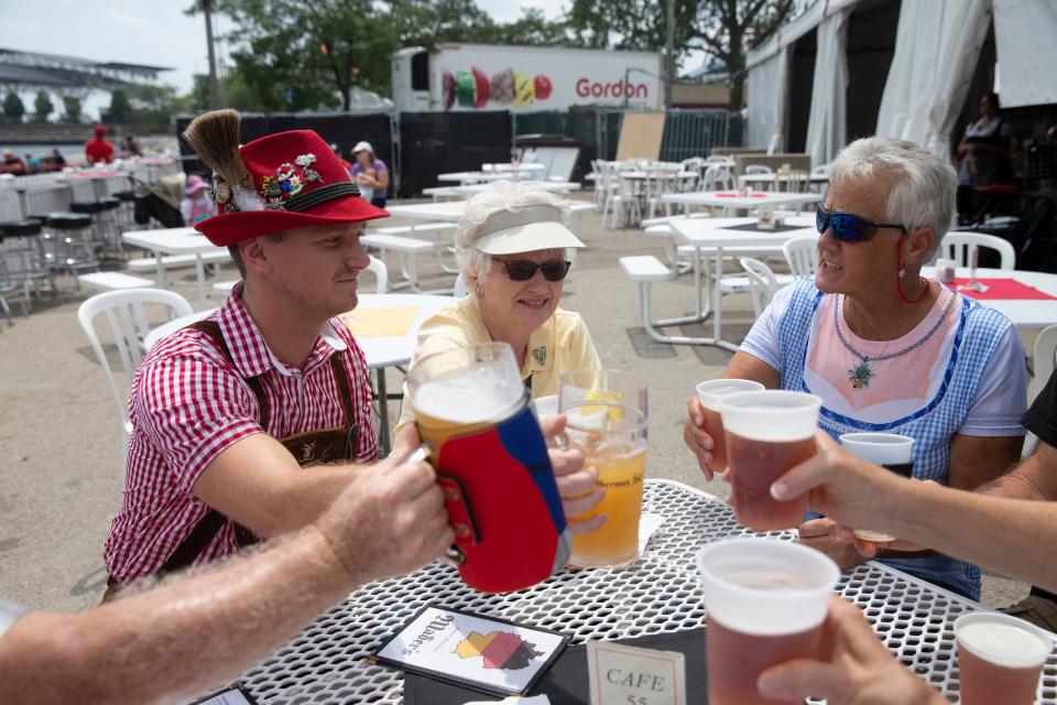 Zach Baker, Donna Gustafson and Christel Springmire raise their glasses to cheers with their family members during a previous German Fest.