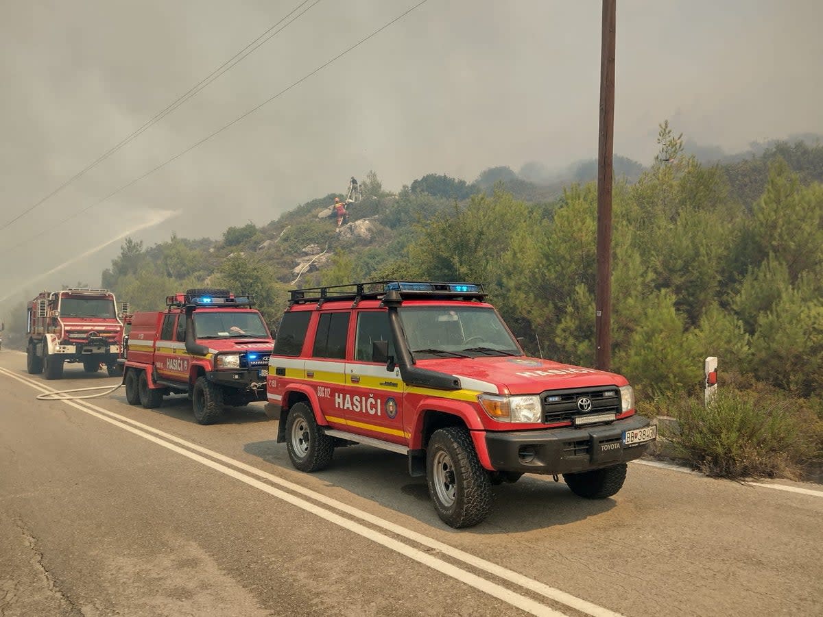 Firetrucks line up as firefighters try to extinguish a wildfire burning on Rhodes Island, Greece (Reuters)