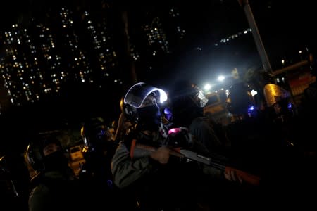 Riot police stand guard as they disperse anti-government protesters demonstrating outside the police station in Ma On Shan, in Hong Kong