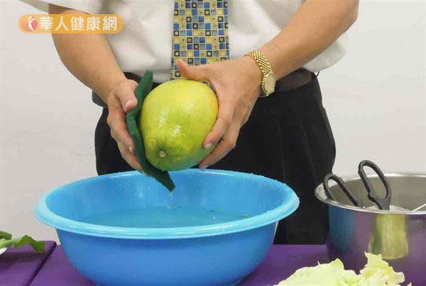 用菜瓜布清洗柚子。