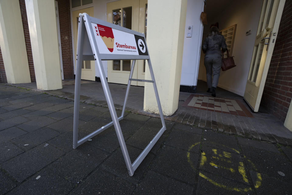 A woman enters a polling station to cast her ballot for the provincial elections in Amsterdam, Netherlands, Wednesday, March 15, 2023. (AP Photo/Peter Dejong)