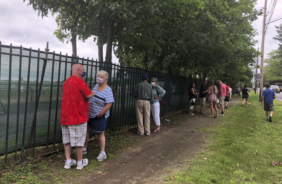 Horse racing fans talk along the fence outside Saratoga Race Course in Saratoga Springs, N.Y., Thursday, July 16, 2020. A Saratoga season like no other is open, with fans barred from attending the start of the 152nd meet in track history and most likely the entire 40 days of racing. (AP Photo/John Kekis)